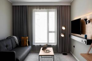 a living room with a couch and a window at Moxy Milton Keynes in Milton Keynes