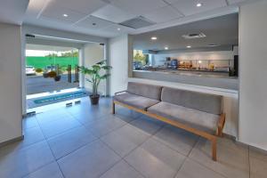 a living room with a bench and a kitchen at City Express Junior by Marriott Cancun in Cancún