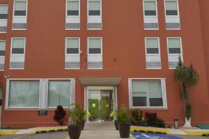 un edificio naranja con ventanas blancas y puerta en City Express Junior by Marriott Cancun en Cancún