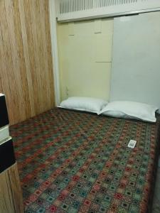 a room with two beds and a rug on the floor at Near Airport AC Double Room at a Budget Inn in Mumbai