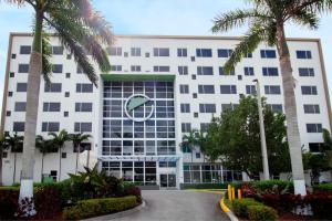 a large white building with palm trees in front of it at Element Miami Doral in Miami