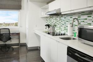cocina con armarios blancos, fregadero y ventana en Element Miami Doral, en Miami
