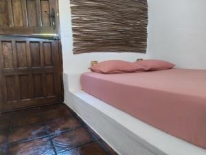 1 dormitorio con 1 cama y puerta de madera en Casa rural la luz de Ari, en Traspinedo