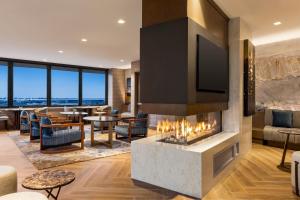 a living room with a fireplace and a tv at Marriott New York JFK Airport in Queens