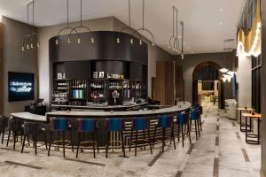 a lobby with a bar with blue stools at Marriott New York JFK Airport in Queens