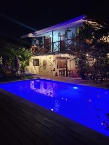 ein Schwimmbad in der Nacht mit einem Haus im Hintergrund in der Unterkunft Mecca in Puerto Viejo
