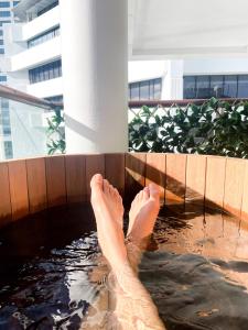 a person with their feet in a pool of water at Luxury Apartment - Parking - Hot Tub - Stunning Views in Auckland