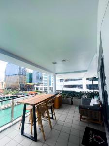 a balcony with a wooden table and a view of the city at Luxury Apartment - Parking - Hot Tub - Stunning Views in Auckland