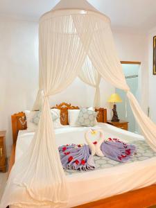 een slaapkamer met een bed met twee zwanen erop bij Sakti OceanView Nusa Penida in Nusa Penida