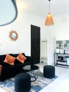 ein Wohnzimmer mit einem schwarzen Sofa und einem Tisch in der Unterkunft Gem Villa 67, biệt thự 15 phòng có hồ bơi lớn in Ho-Chi-Minh-Stadt