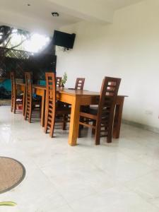 een houten eettafel met houten stoelen bij Senanayaka Holiday Inn in Polonnaruwa