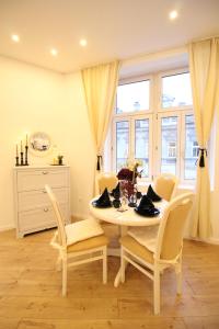 un comedor blanco con mesa y sillas en Cozy rooms in Liesing, en Viena