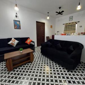 オールド･ゴアにあるRiverside, The European Homestay! Apartments 3 and 4! Luxury and Value in Goa's delightful locationのリビングルーム(黒いソファ、コーヒーテーブル付)