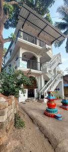 オールド･ゴアにあるRiverside, The European Homestay! Apartments 3 and 4! Luxury and Value in Goa's delightful locationのバルコニーと階段付きの大きな白い家です。