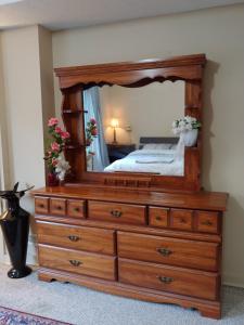 a bedroom with a large wooden dresser with a mirror at Room with private bath across train station in Burlington