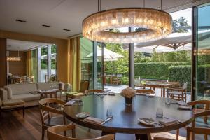 a dining room with a table and chairs and a chandelier at InterContinental Genève by IHG in Geneva