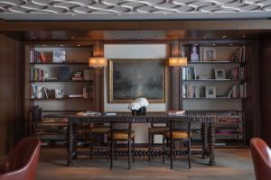 a dining room with a table and chairs and bookshelves at InterContinental Genève by IHG in Geneva
