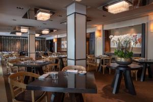 a restaurant with tables and chairs and flowers on the wall at InterContinental Genève by IHG in Geneva