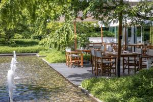 a restaurant with tables and chairs and a fountain at InterContinental Genève by IHG in Geneva