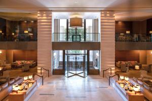 a lobby of a hotel with tables and chairs at InterContinental Genève by IHG in Geneva