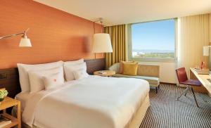 a hotel room with a large bed and a desk at InterContinental Genève by IHG in Geneva