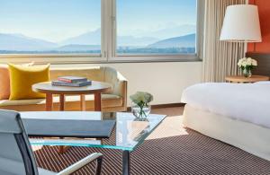 a hotel room with a bed and a table at InterContinental Genève by IHG in Geneva
