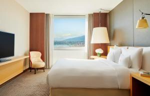 um quarto de hotel com uma cama grande e uma janela em InterContinental Genève, an IHG Hotel em Genebra