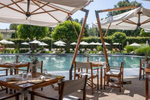 a restaurant with tables and umbrellas in front of a pool at InterContinental Genève by IHG in Geneva