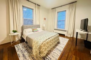 a bedroom with a bed and a flat screen tv at Beautiful 2BR apt in Beach community, Close to Train and hwys! ONLY 1 hr to NYC! in Norwalk