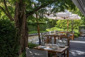 a table and chairs under an umbrella on a patio at InterContinental Genève by IHG in Geneva