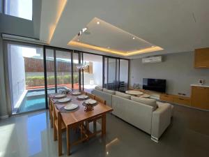 a living room with a table and a couch at Amazing Pool 3BR Villa @ Chalong in Phuket Town