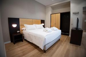 ein Schlafzimmer mit einem weißen Bett mit zwei Handtüchern darauf in der Unterkunft Antum Hotel in Benevento