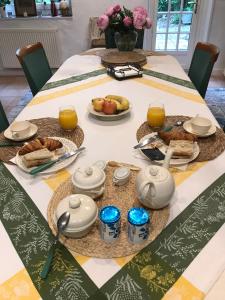 una mesa con alimentos para el desayuno y zumo de naranja en ella en Le 7 du Clos Fleuri, 