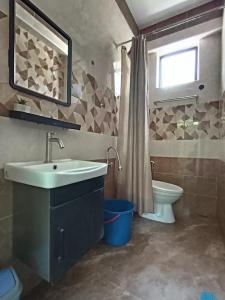 een badkamer met een wastafel, een toilet en een raam bij Dango1881muslim riverstay in Padang Rengas