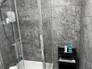 a bathroom with a shower with a toilet and towels at Morden Apartment in City Centre in Manchester