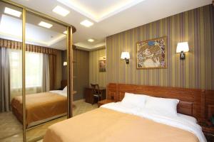 サラトフにあるBoutique Hotel Absoluteのベッド2台と鏡が備わるホテルルームです。
