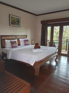 a bedroom with a large bed with a teddy bear on it at Grand Manita Beach Resort in Lamai