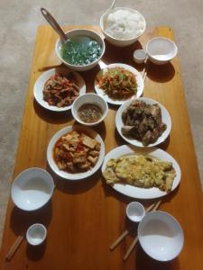 a table with many plates of food on it at Hoàng nam Homestay in Quang Ba