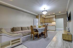 cocina y sala de estar con mesa y sofá en «Casamia» апартаменты с 2 спальнями, en Bishkek