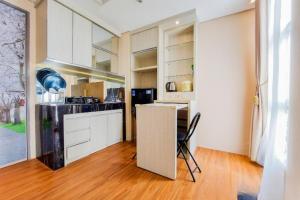 uma cozinha com armários brancos e uma mesa num quarto em comfy corner studio apartment em Ciater-hilir