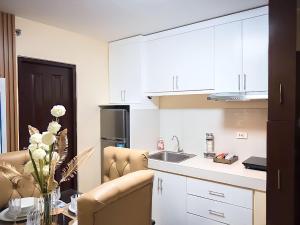 a kitchen with white cabinets and a sink and a table at Affordable 2 Bed Condo Rental in Davao City with Wifi & Netflix, Swimming Pool, Gym & Billiard Hall in Davao City