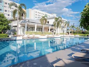 a swimming pool in front of a building at Affordable 2 Bed Condo Rental in Davao City with Wifi & Netflix, Swimming Pool, Gym & Billiard Hall in Davao City