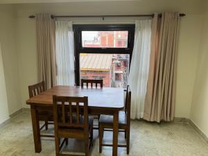 a dining room table with chairs and a window at Ivanna apartment in Pātan