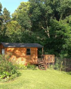 a small wooden cabin with a deck in a yard at Me, myself, I Glamping in Pietermaritzburg