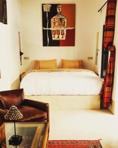 um quarto com uma cama e uma cadeira em Riad Les 5 Soeurs em Marrakech