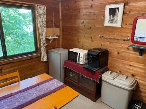 um pequeno quarto com um micro-ondas e um frigorífico em Zao Pension Aramiya - Vacation STAY 86181v em Kaminoyama