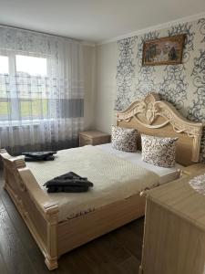 1 dormitorio con 1 cama grande con marco de madera en Карпатські Зорі, en Pilipets