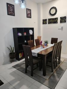 a dining room with a table and chairs at Lekir baiduri homestay in Sitiawan