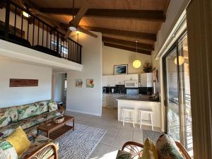 uma sala de estar com um sofá e uma cozinha em Oceanfront Penthouse with Loft em Kailua-Kona