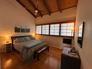 a bedroom with a bed and a large window at Oceanfront Penthouse with Loft in Kailua-Kona